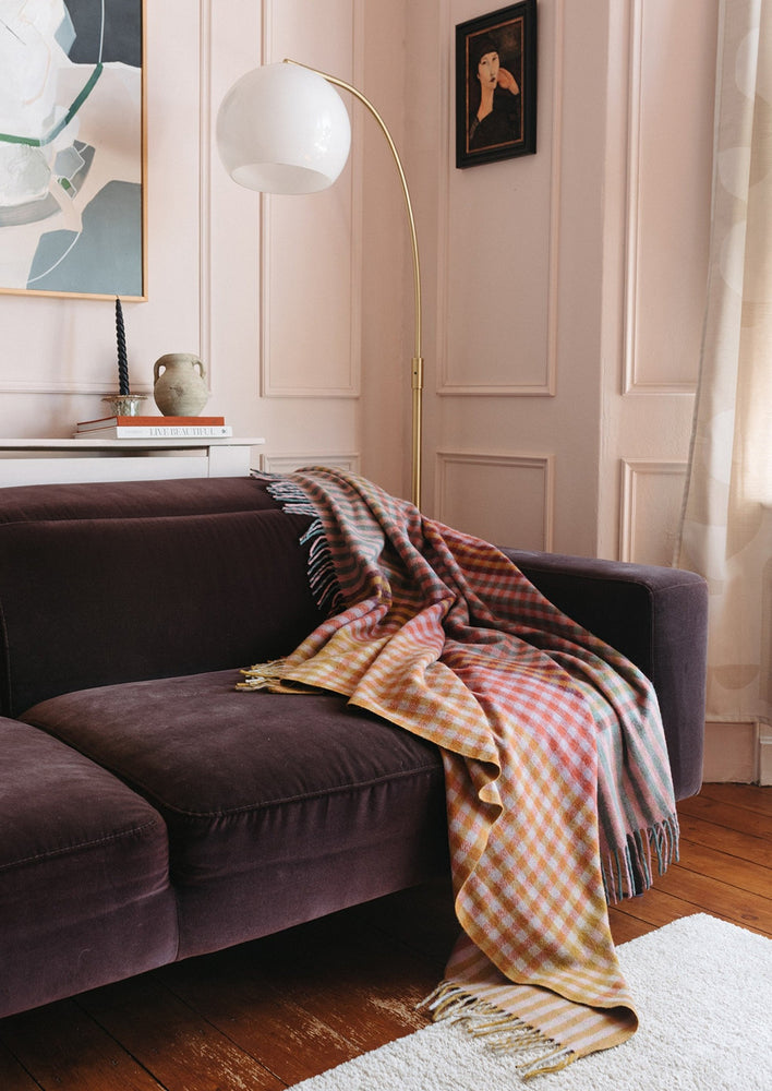 3: A colorful gingham check blanket in tones of lilac, magenta, and yellow.