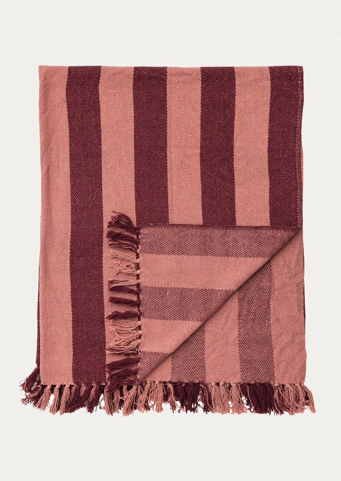 A folded throw blanket with vertical burgundy and pink stripes and fringed edges.