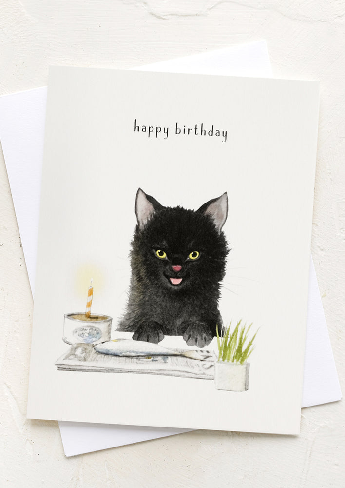 A card with illustration of cat eating a fish, text reads "happy birthday".