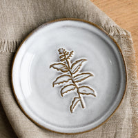 Feverfew: A grey glazed brown clay mini plate with raised flower design.