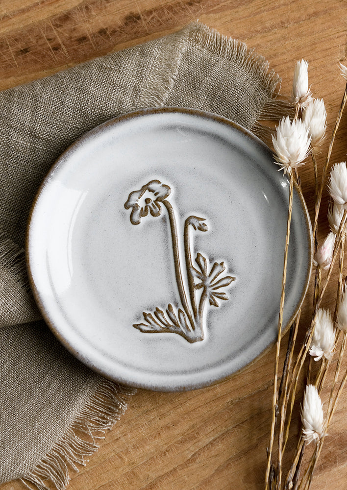 Anemone: A grey glazed brown clay mini plate with raised flower design.