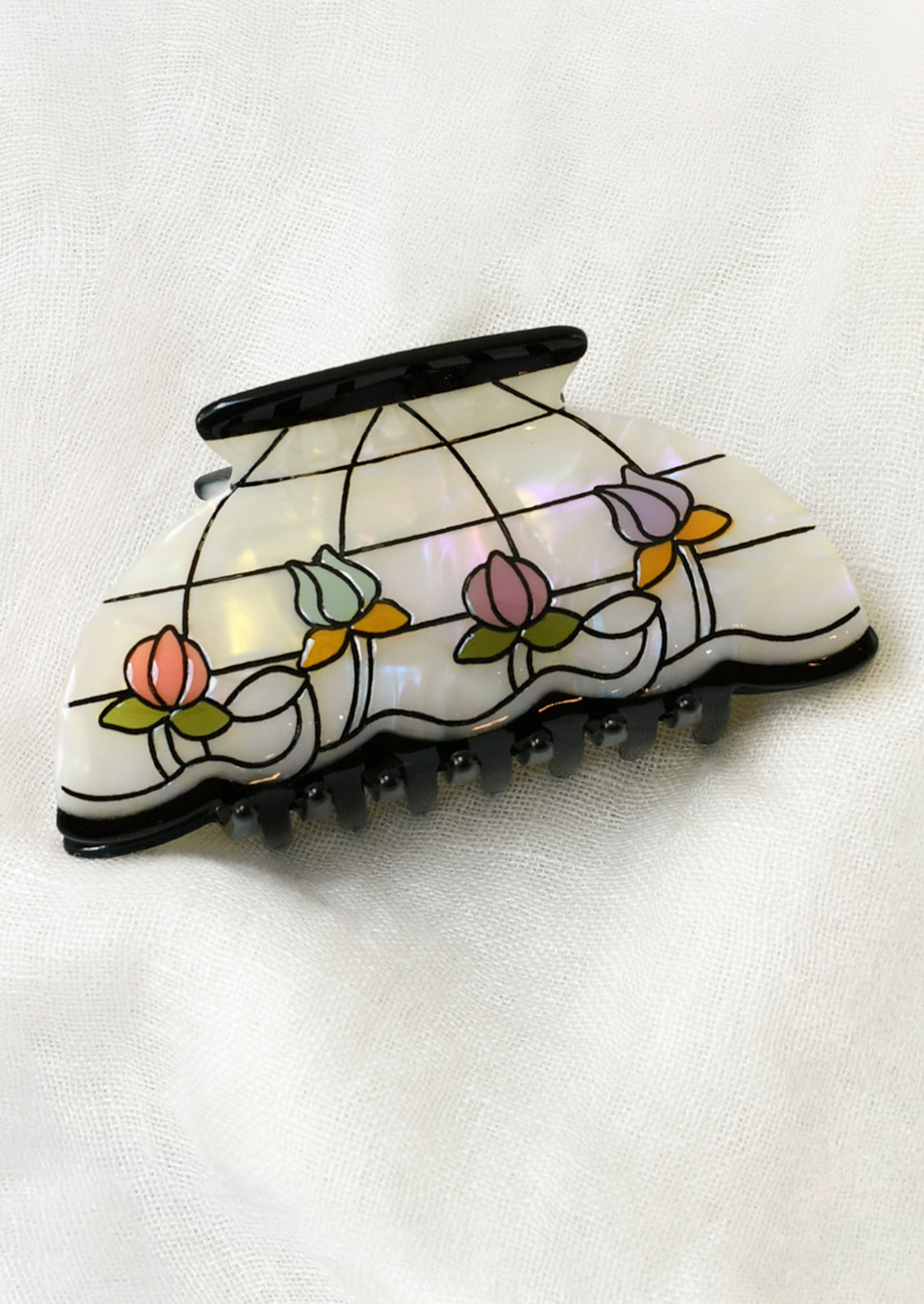 A hair claw shaped like a lamp shade with colorful florals and a grid pattern.