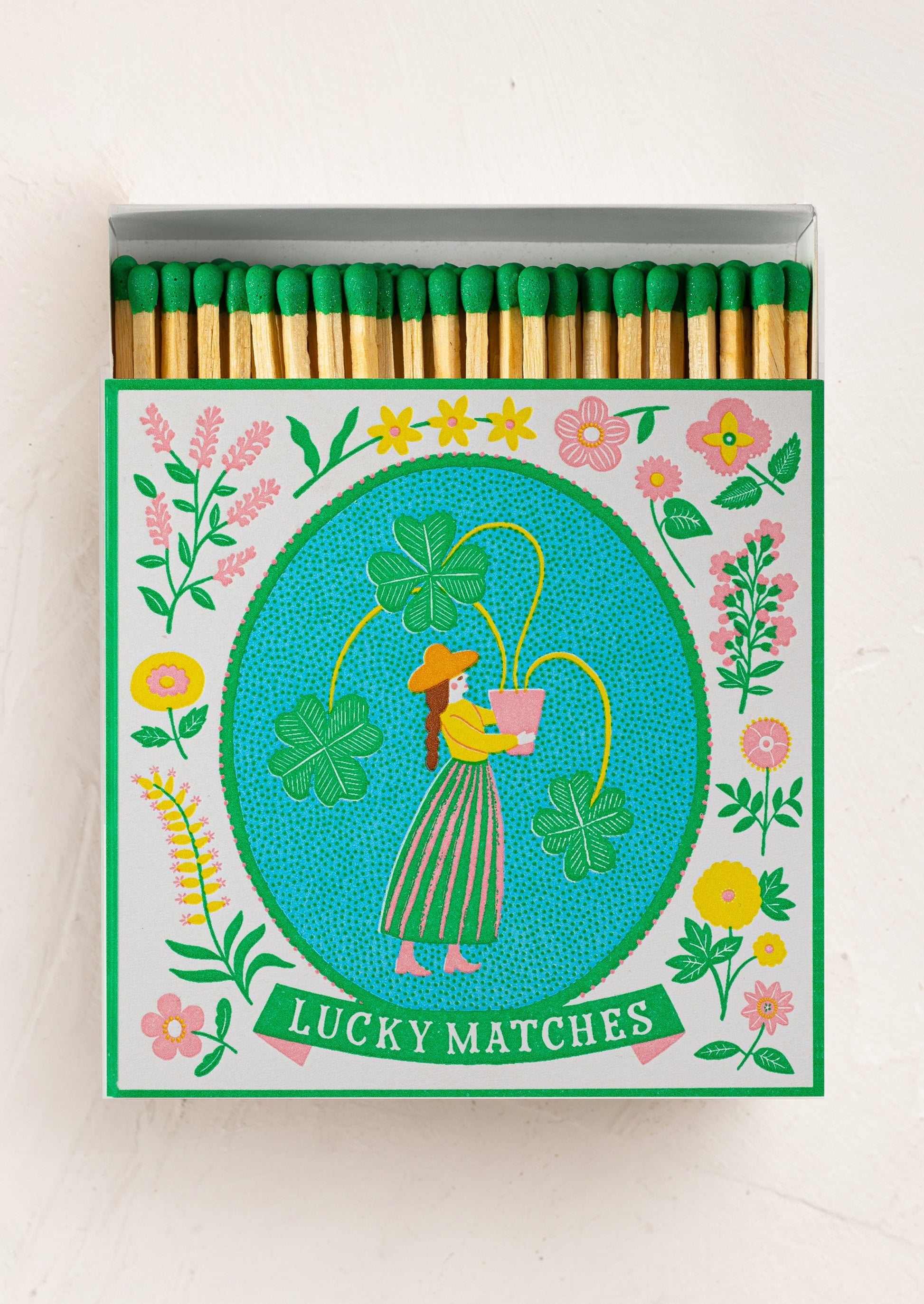 Green tipped matches with a colorful design of a woman holding flowers and text 'Lucky Matches'.