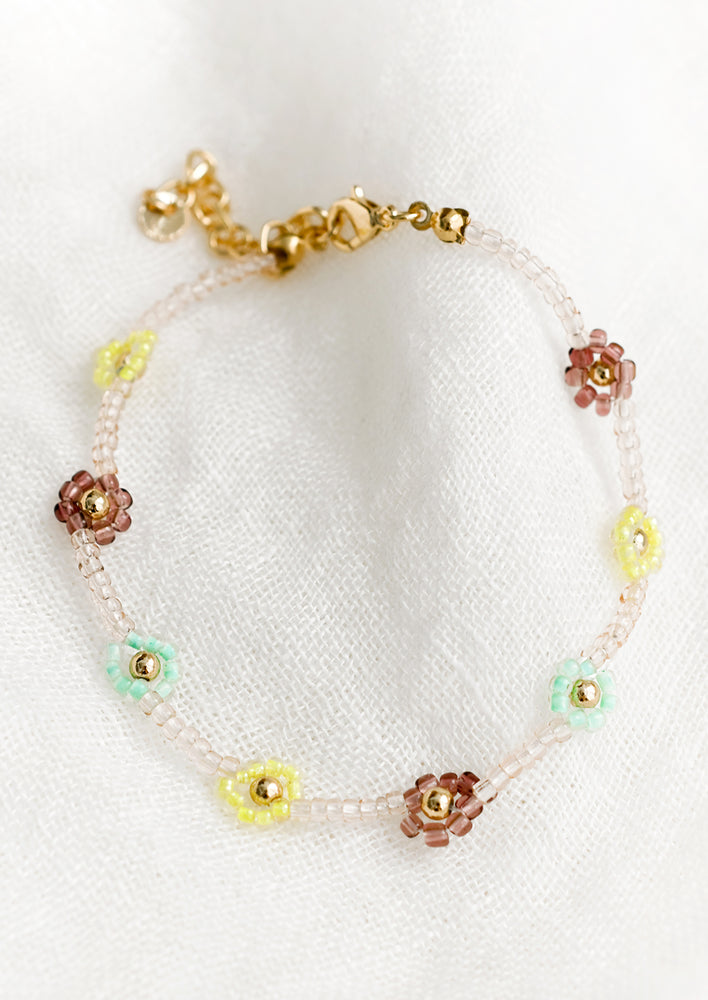 Blush Multi: A beaded bracelet in clear pink beads with yellow, mint and brown beaded flowers.