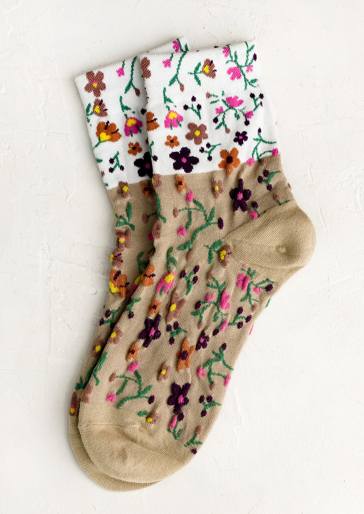 Tan Multi: A pair of two-tone socks in white and tan with multicolor flower pattern.