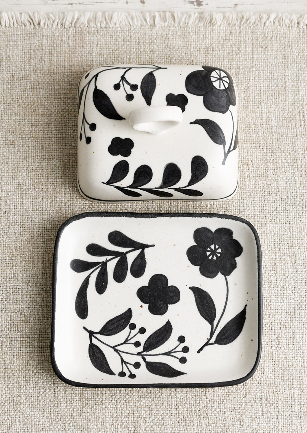 1: A black and white floral print butter dish.