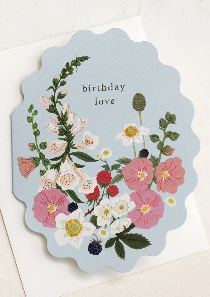 A scalloped edge card with floral print reading "Birthday love".