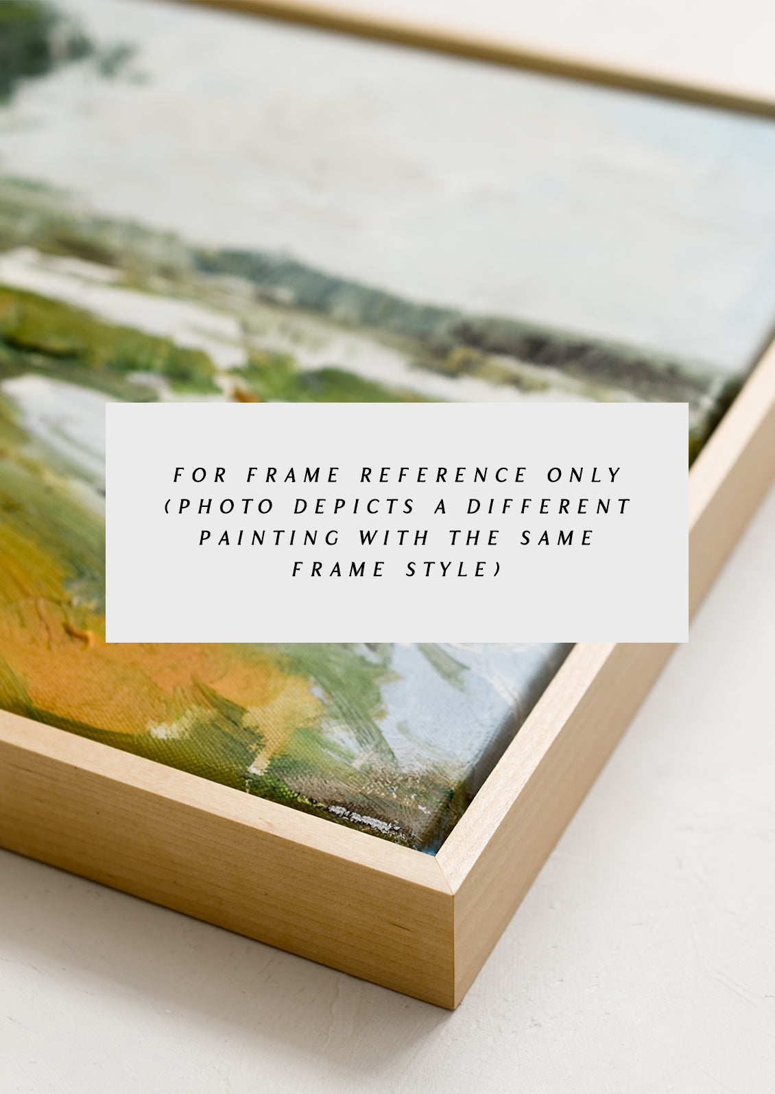 A framed original painting of a cool-colored lakeside landscape setting.