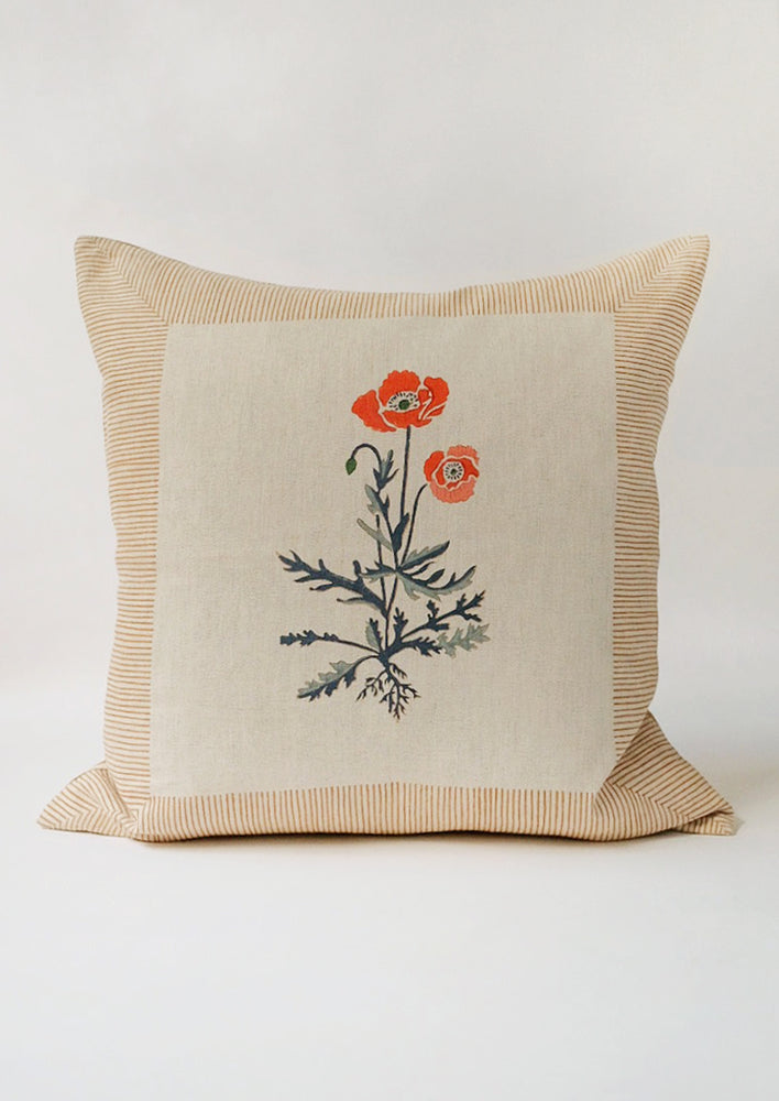 1: A square block printed throw pillow with framed poppy design.