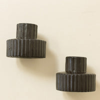 3: Black fluted taper candle holders in short/wide shape.