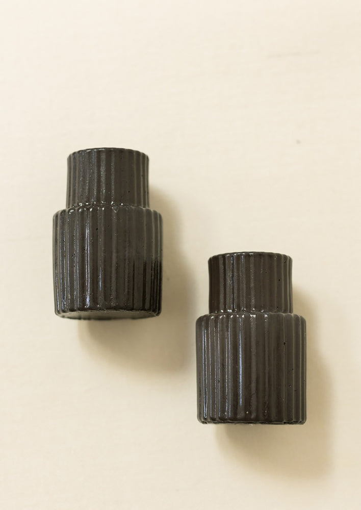 Black fluted taper candle holders in tall shape.