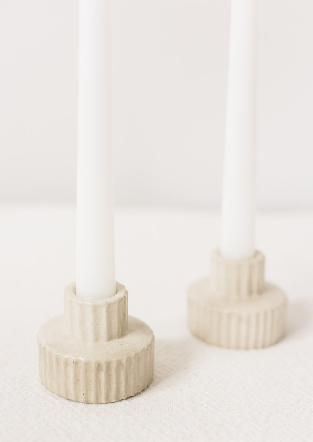 Wide / Natural: A short and wide fluted concrete taper candle holder in natural.