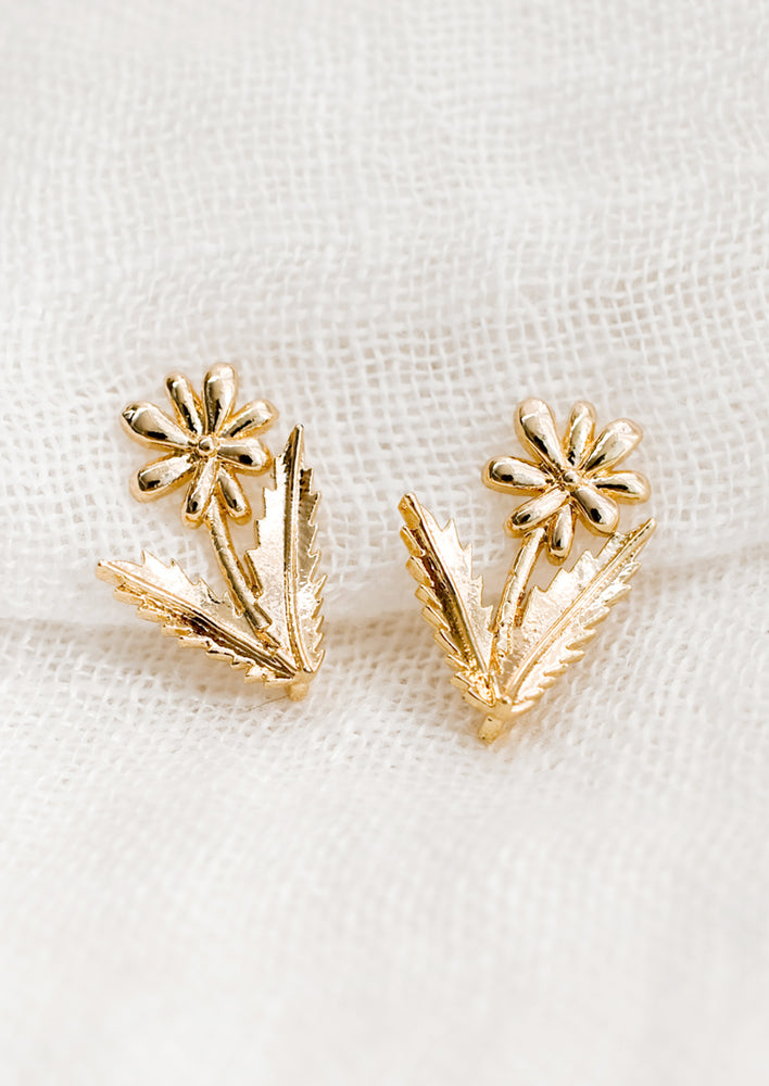 A pair of gold stud earrings in shape of daisy.
