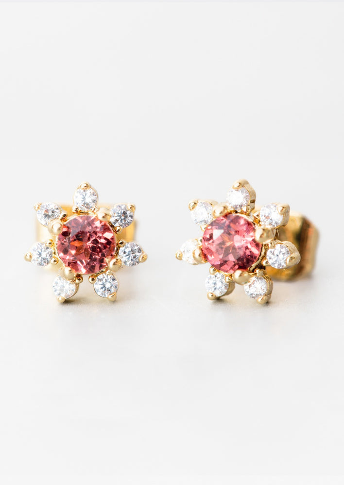 Garnet: A pair of flower shaped studs with gemstone and crystal in red.
