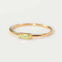 Peridot / Size 5: A gold ring with slim baguette stone in peridot.