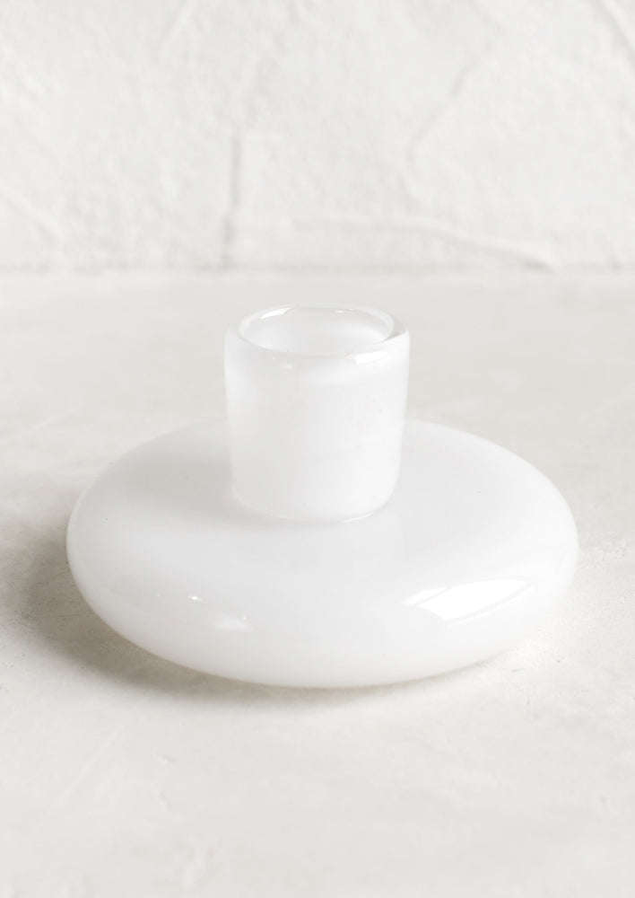 A glass taper candle holder in cotton.
