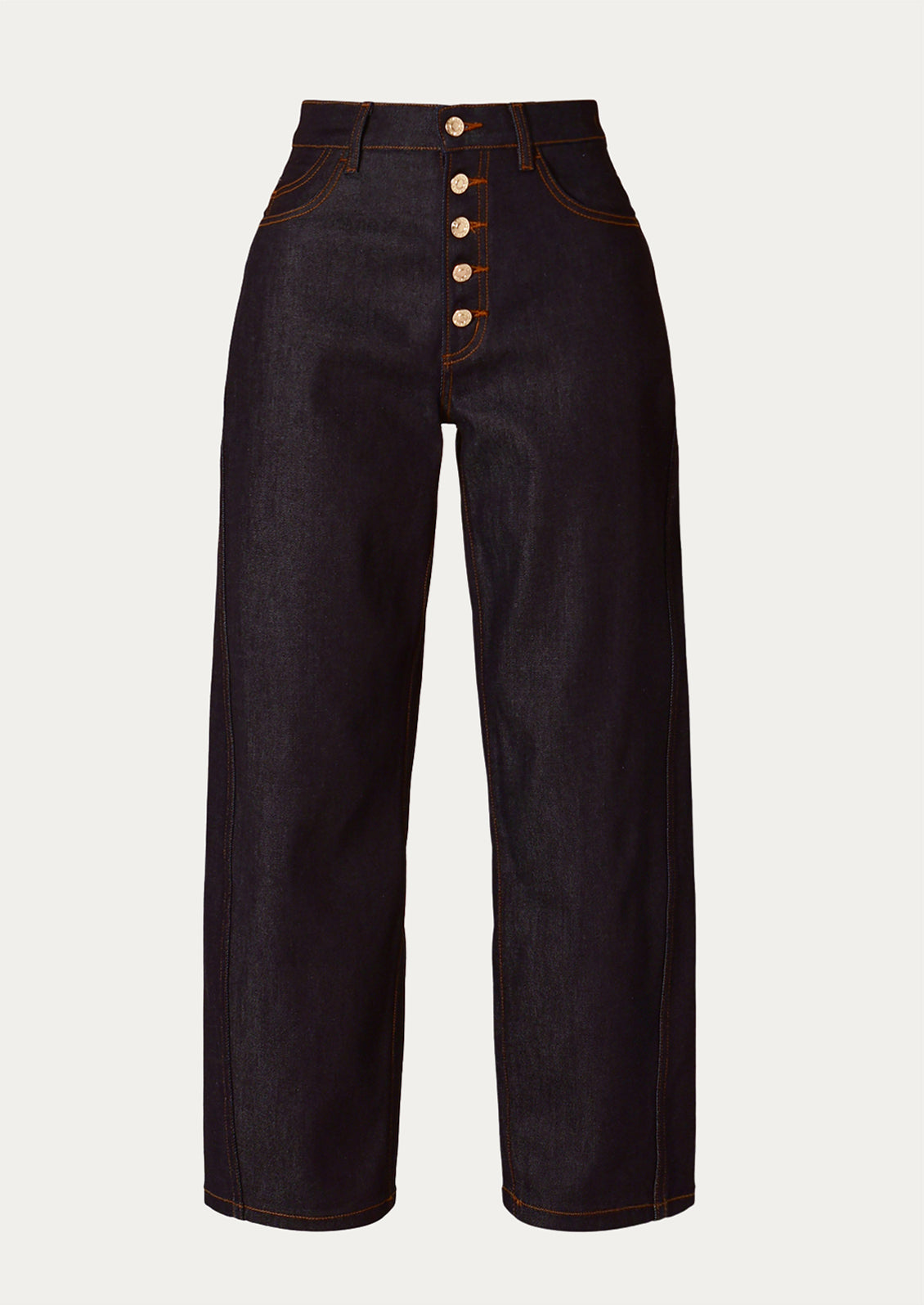 A pair of dark rinse jeans with gold-tone exposed button fly and contrast orange stitching.