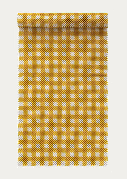 A beaded table runner in yellow and white gingham pattern.