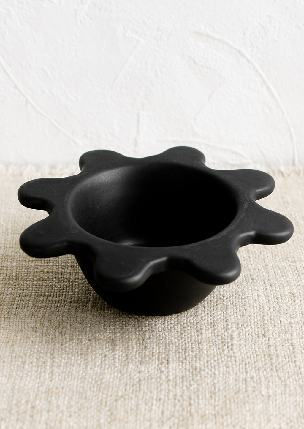 1: A small black ceramic bowl with splatter squiggle shape rim.