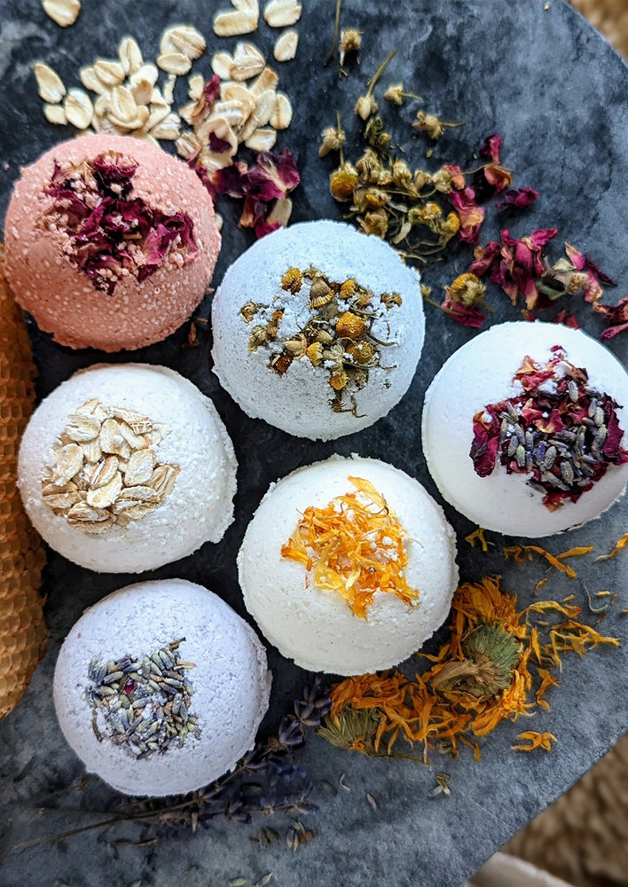 Colorful bath bombs with assorted dried flowers and herbs.