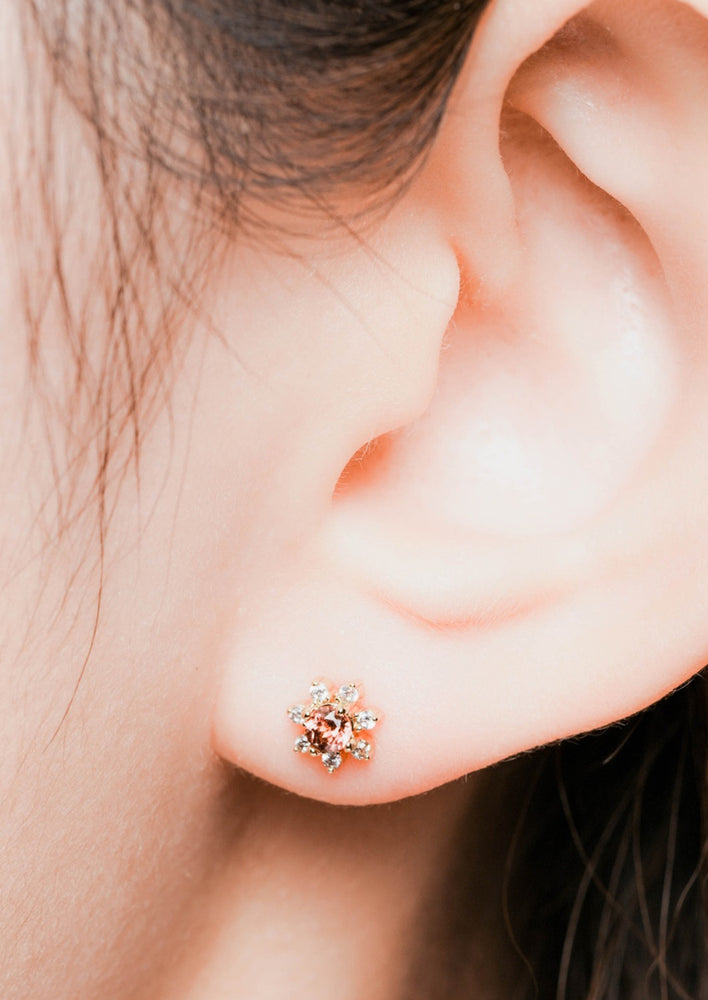 3: A pair of flower shaped studs with gemstone and crystal in red.