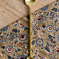 Cocktail Spoon: Gold finish cocktail spoon with circular loop at end of handle.