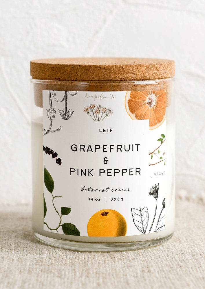 A glass jar candle in Grapefruit & Pink Pepper scent with botanical print label.