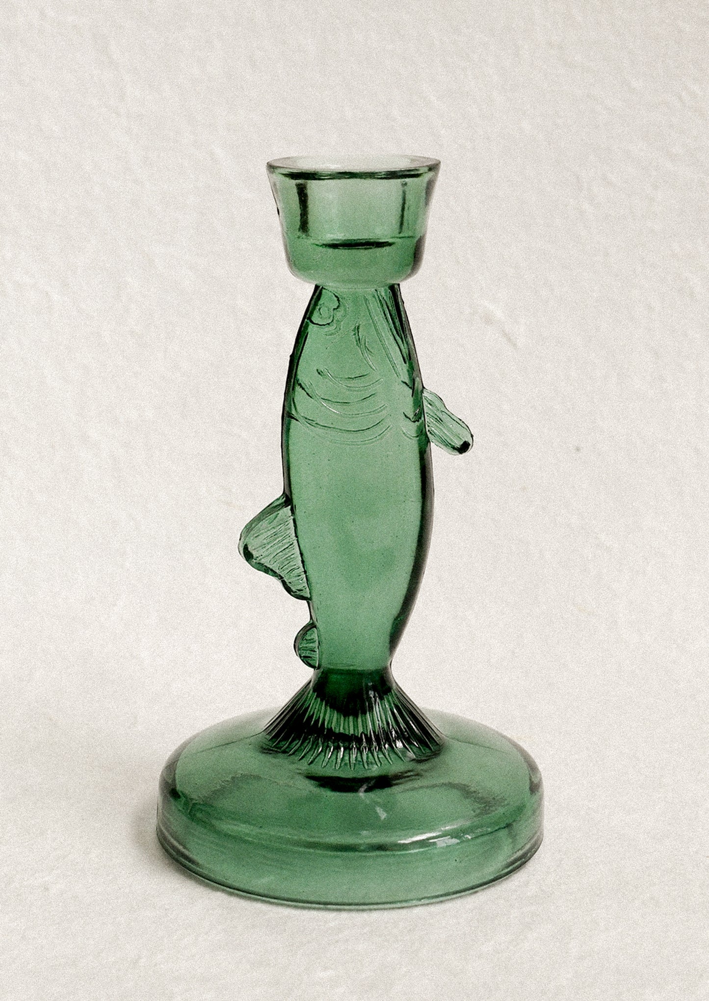 Green glass fish-shaped candle holder.