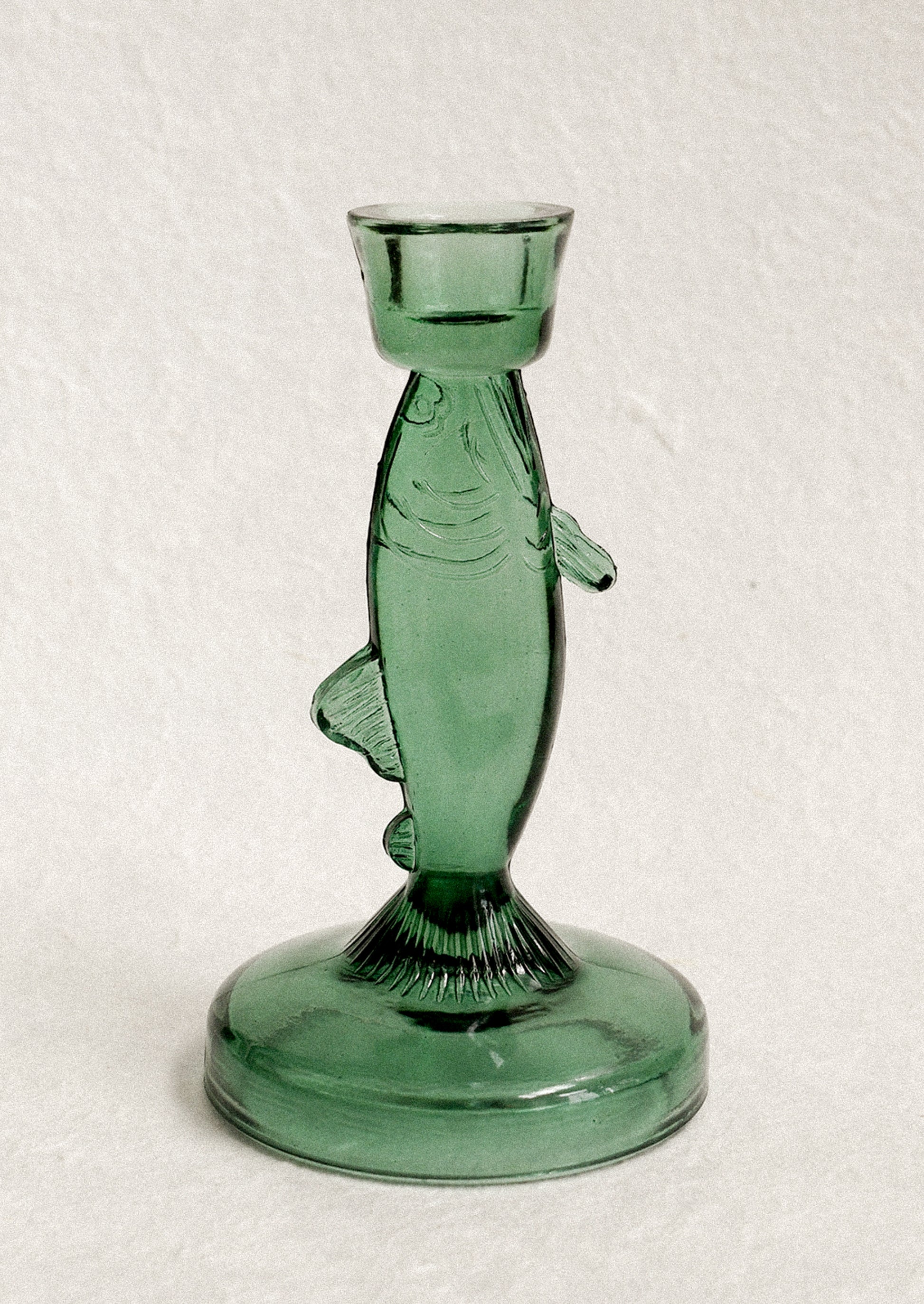 Green glass fish-shaped candle holder.