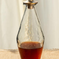 Classic: A hammered glass decanter with modern, tapered shape and brass lid.