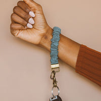 Harbor Blue: A harbor blue scrunchie wristlet keychain around a woman's wrist.