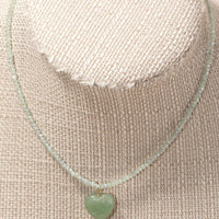 2: A beaded crystal necklace with heart charm on mannequin.