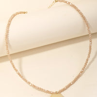 Nectar Multi: A tan beaded crystal necklace with tan stone heart charm.