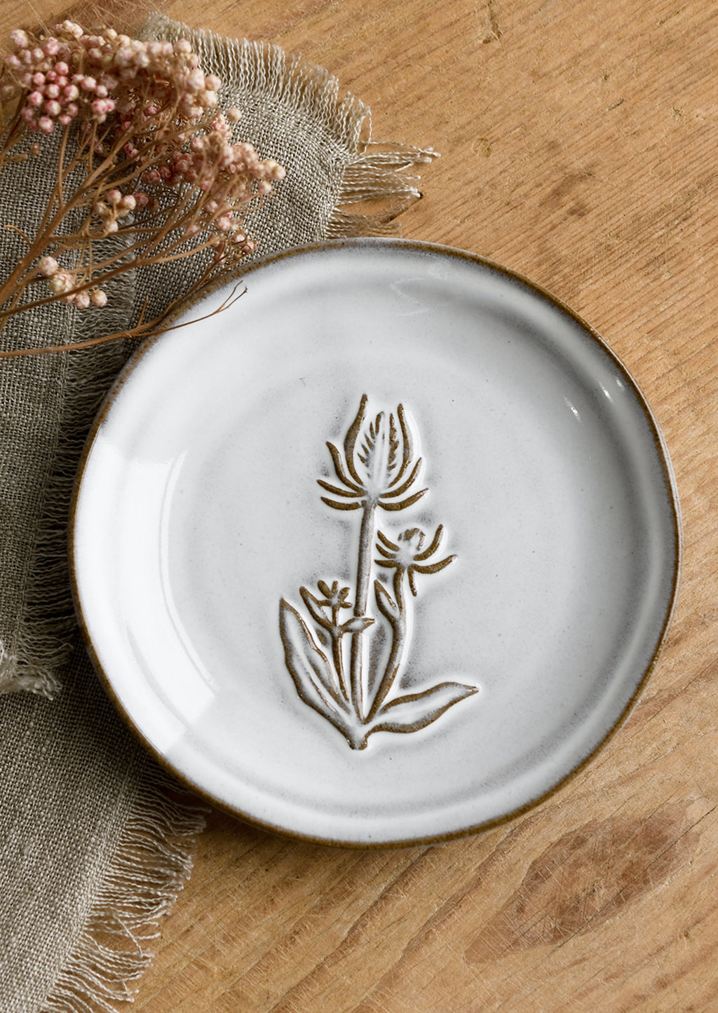 Thistle: A grey glazed brown clay mini plate with raised flower design.