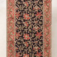 2: A table runner with black and red floral print.