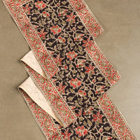 1: A table runner with black and red floral print.