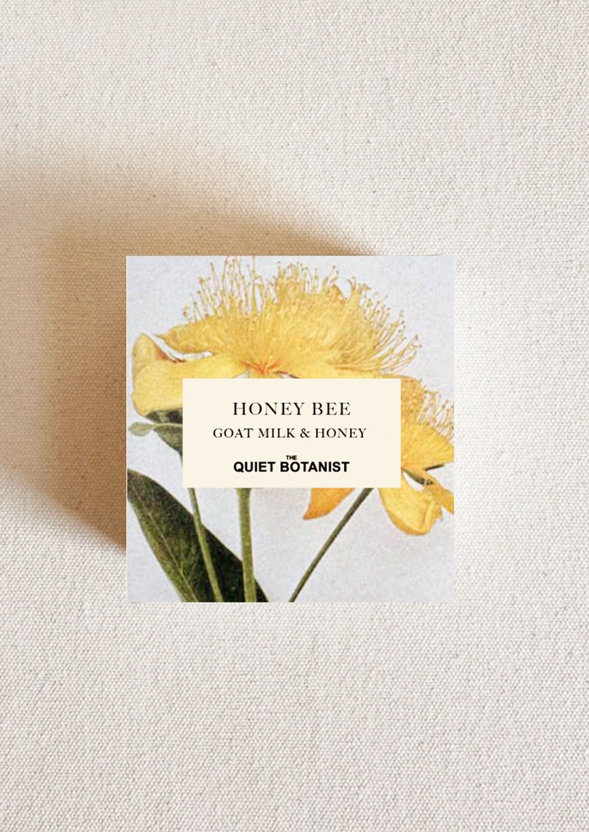 Product packaging with yellow flowers and 'Honey Bee' label on a textured beige background