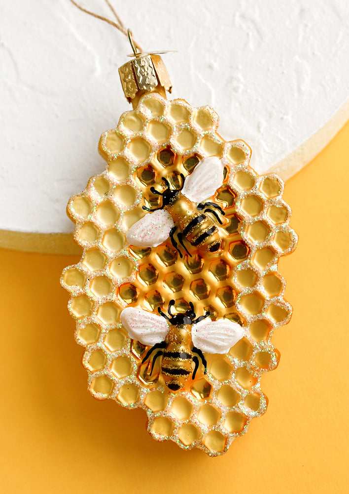 A glass ornament of bees on honeycomb.