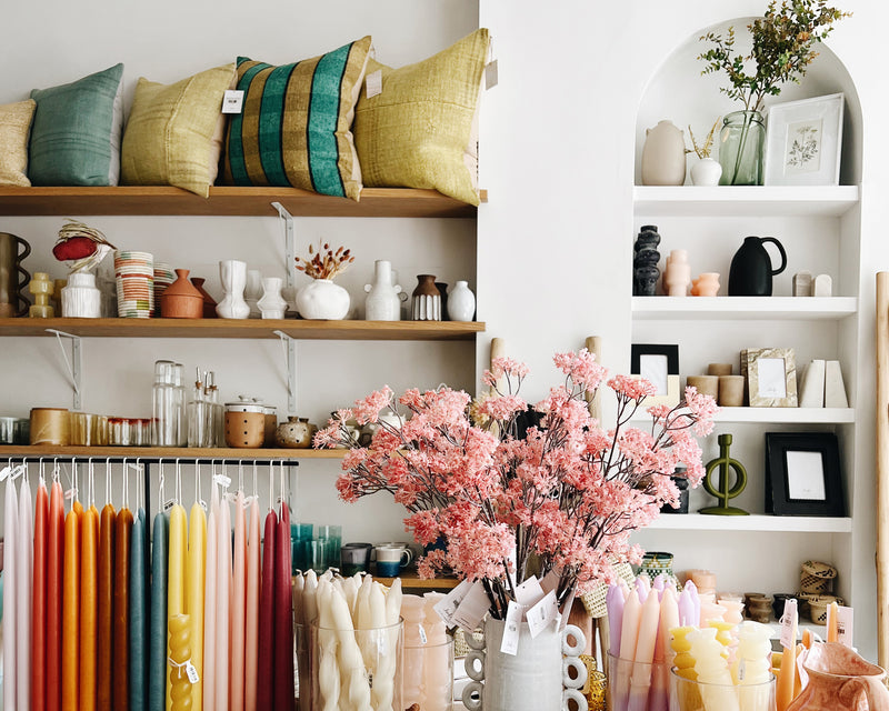 Shelves of pillows, vases and mugs in a home goods shop