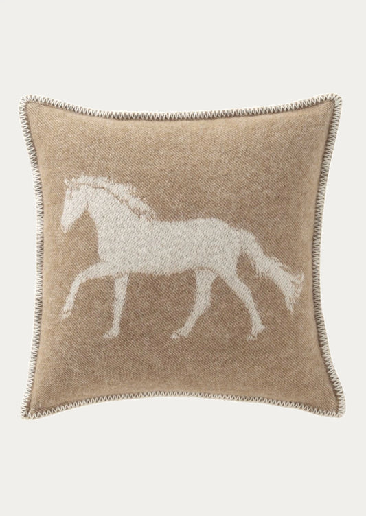 A square beige throw pillow with a white woven silhouette of a horse on the front, finished with a decorative braided border, shown against a light gray background.