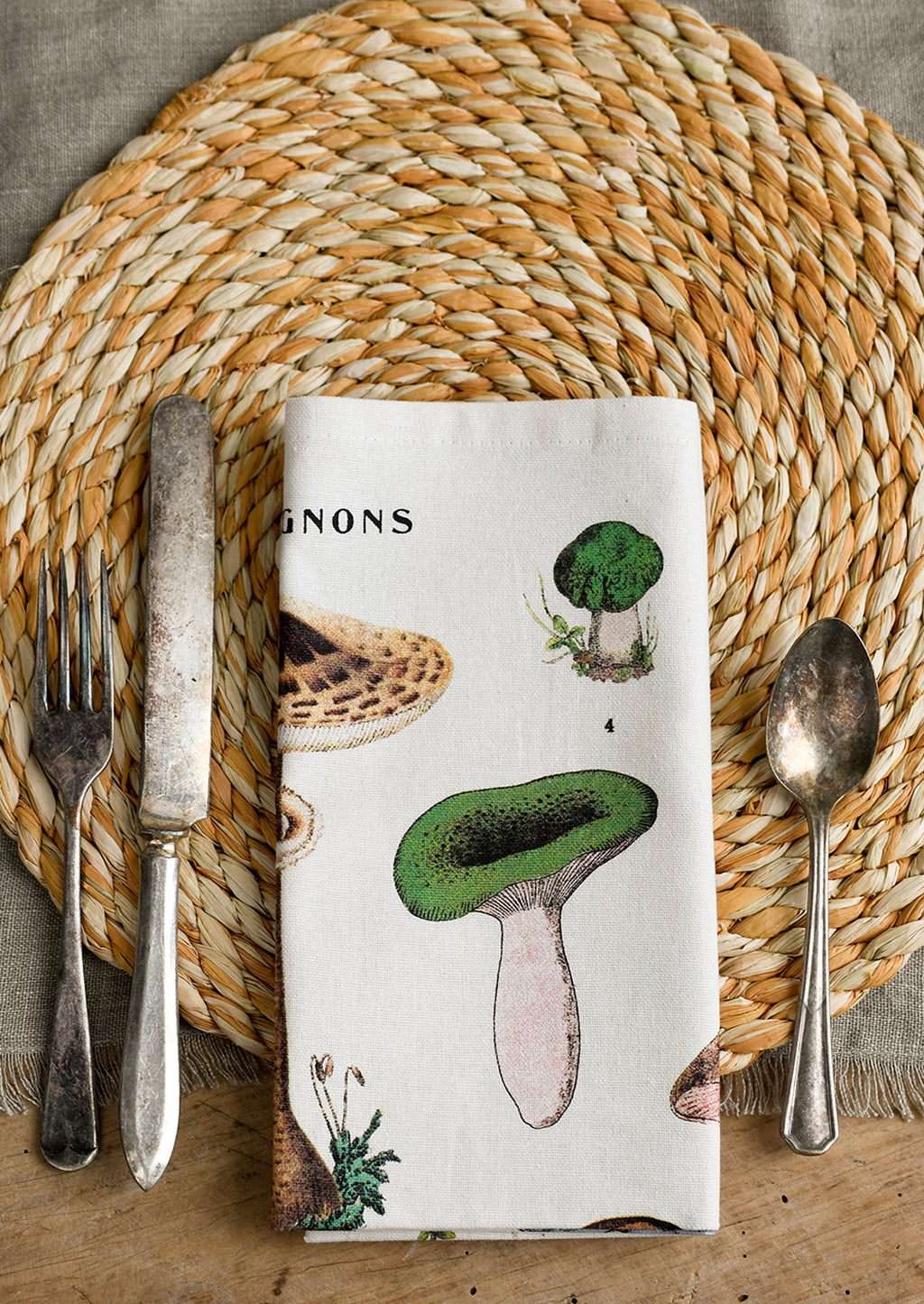 5: A place setting with mushroom print napkin, folded.