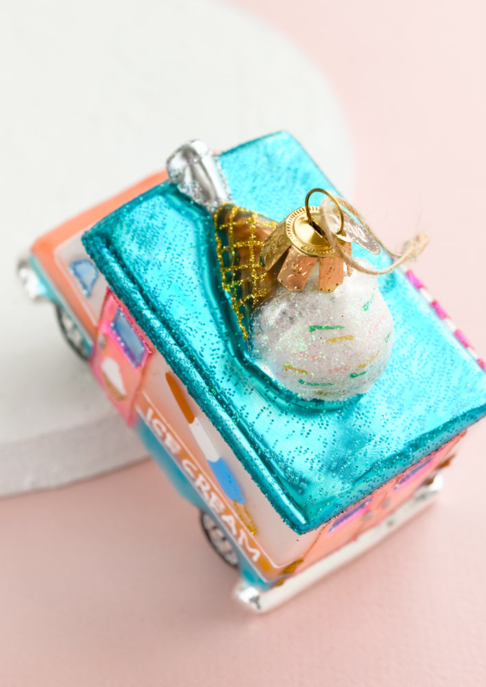 A holiday glass ornament of an ice cream truck.
