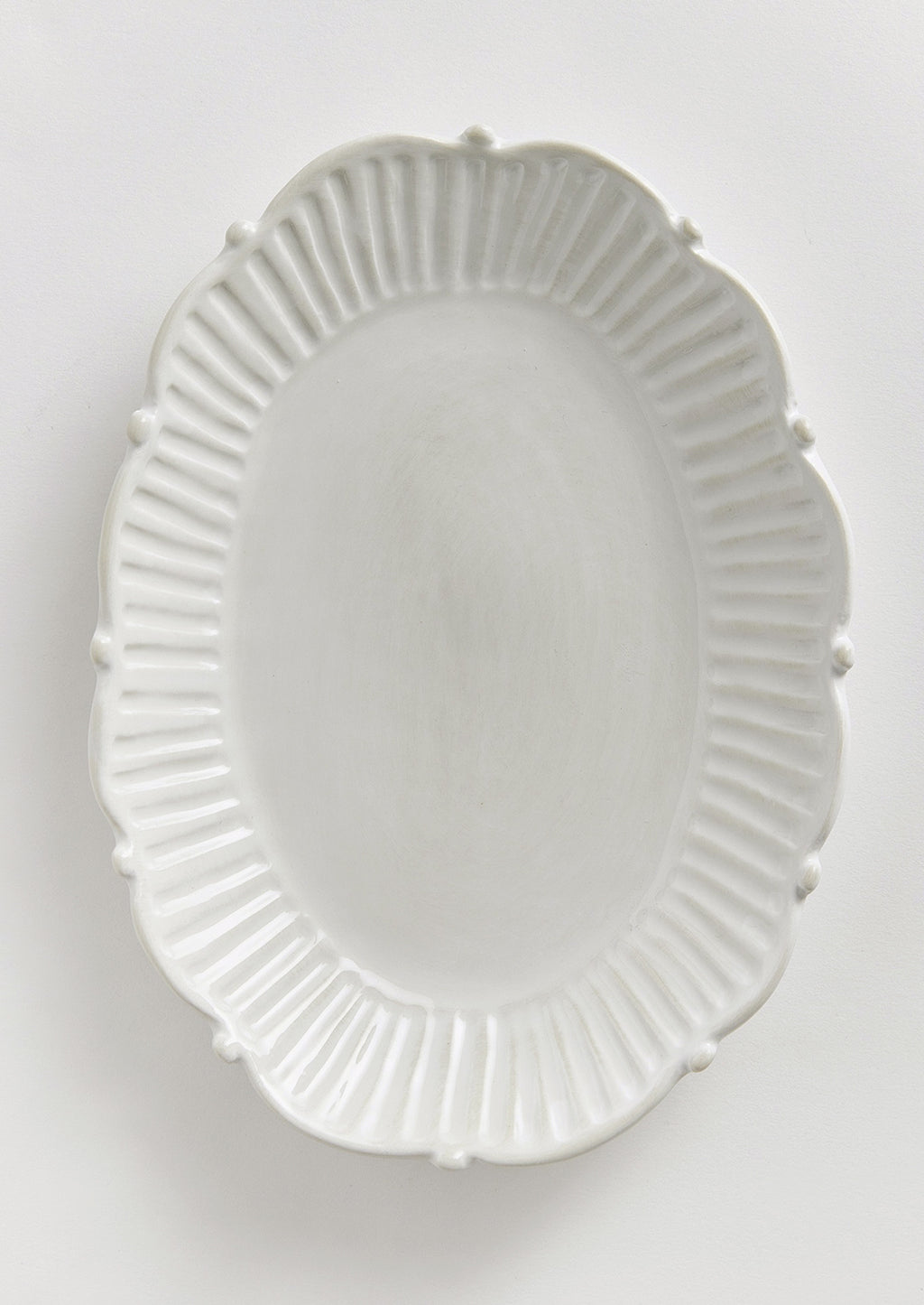 1: An oval shaped tray with ruffled and pleated border with ball detail around edges.