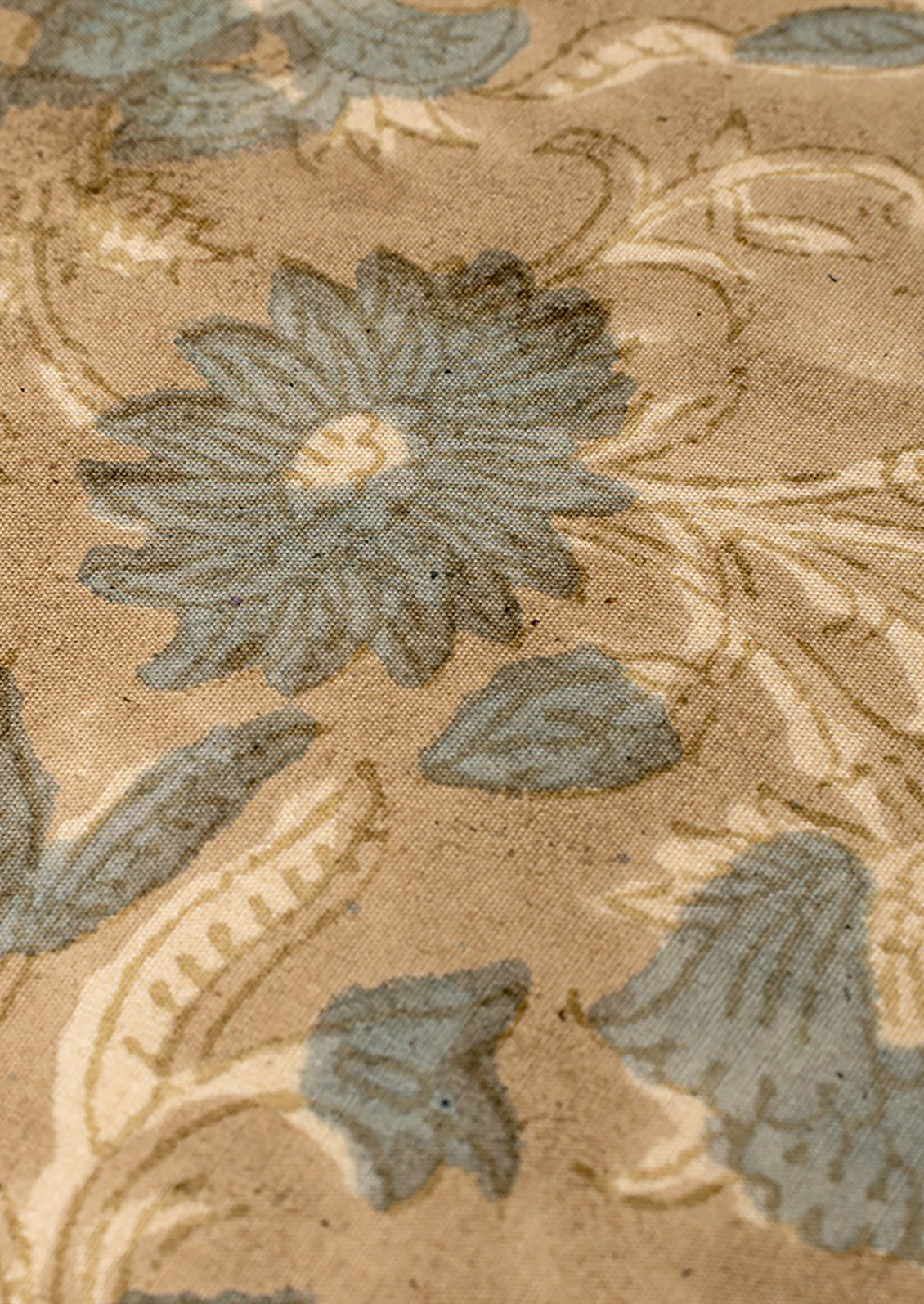 A block printed cotton throw pillow in taupe and dusty blue floral pattern.