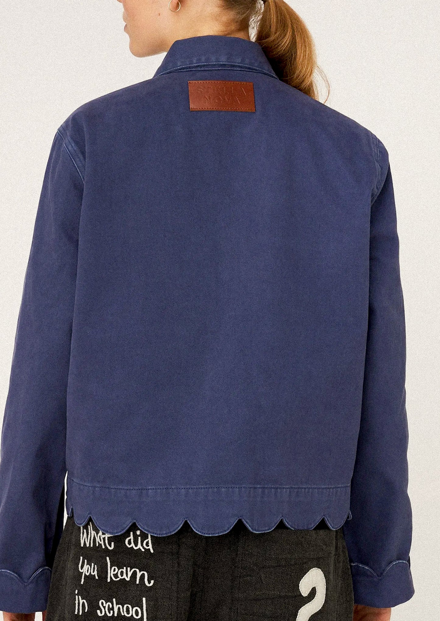 Person wearing a blue jacket with scalloped hem.