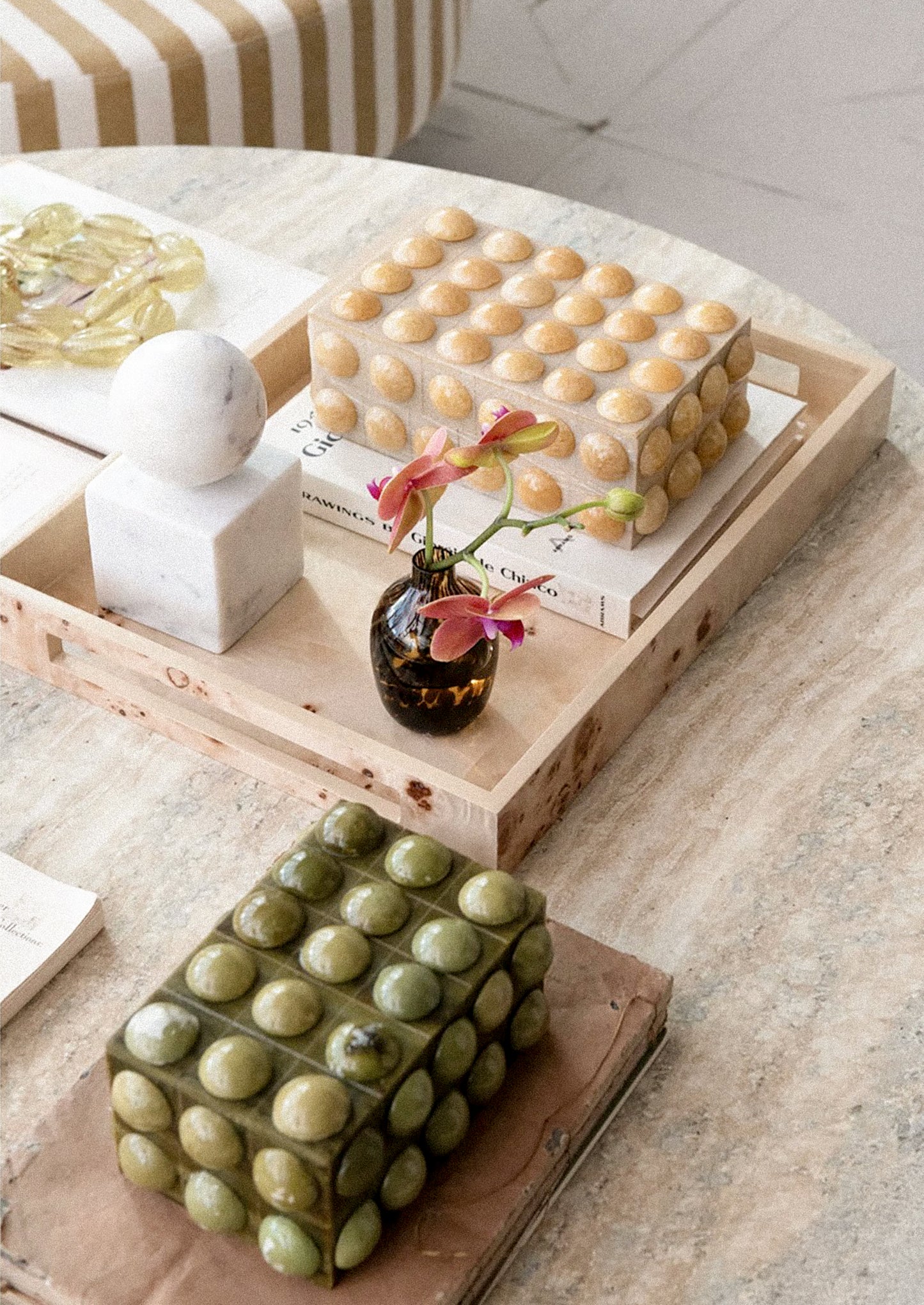 Decorative boxes with hobnail texture stacked on top of each other on a book.