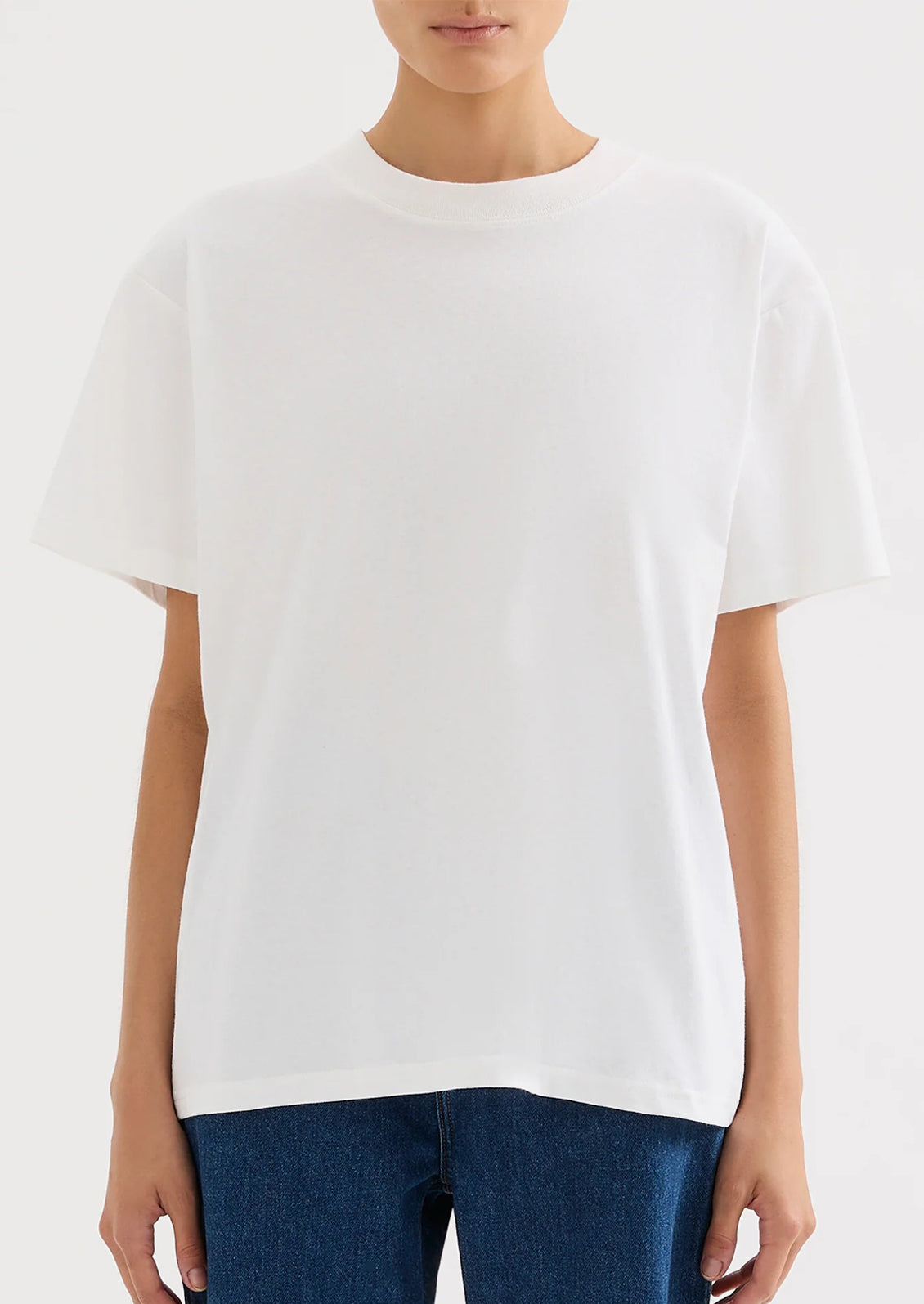 A person wearing an oversized fit white t-shirt.