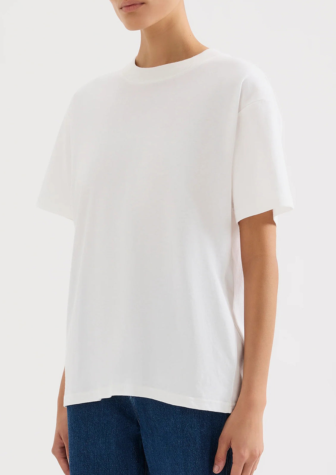 A person wearing an oversized fit white t-shirt.