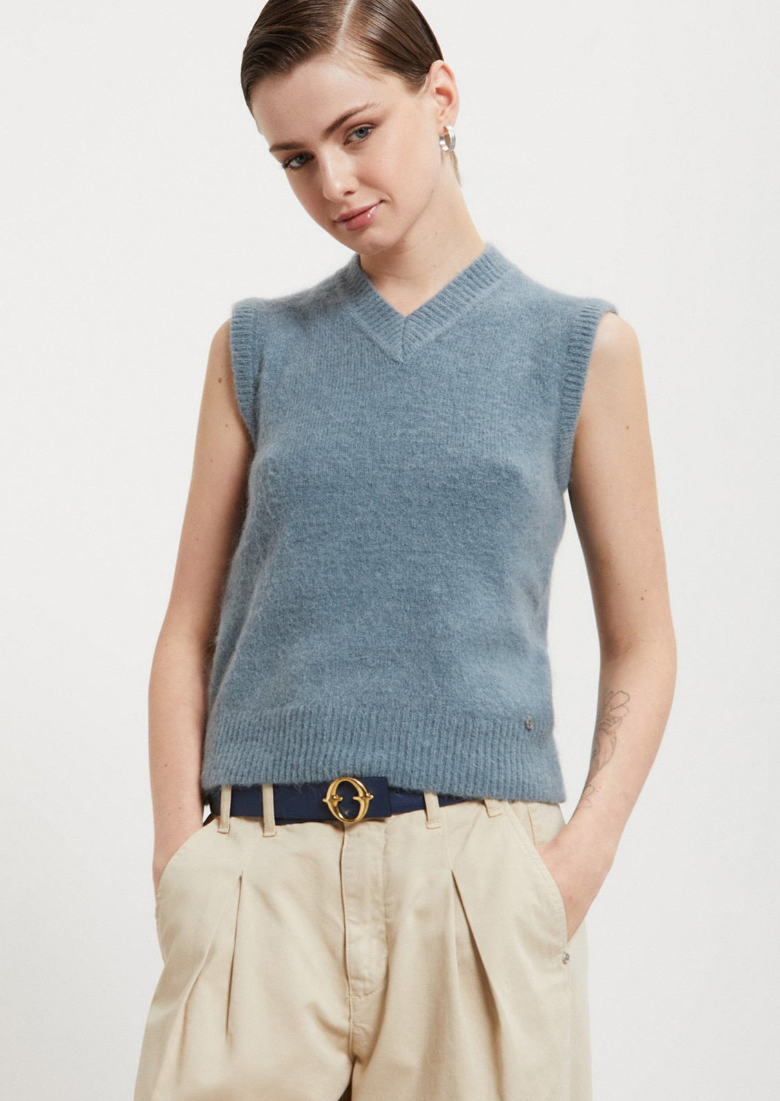 A v-neck sleeveless sweater vest in dusty blue color.