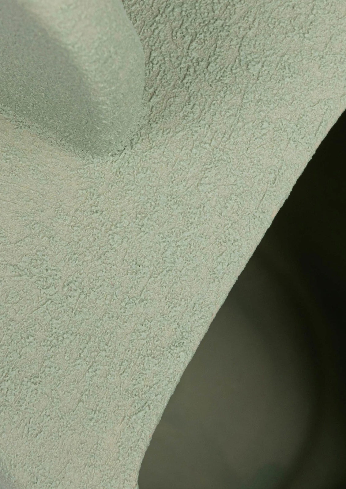 Mint green ceramic pitcher with close up of rough textured glaze.